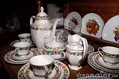 Ceramic tableware for coffee or tea, consisting of cups with plates and a tall jug Editorial Stock Photo