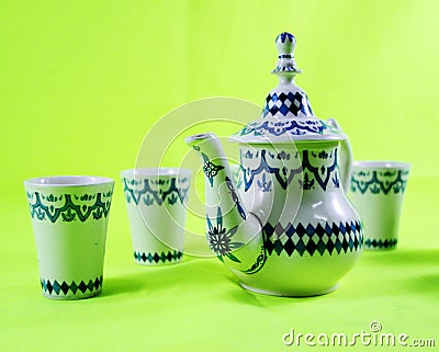 Ceramic teapot and cup on the green background Stock Photo