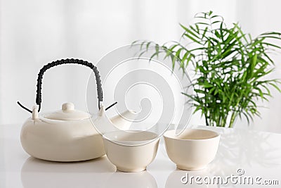 Ceramic teapot and cups on the table Stock Photo