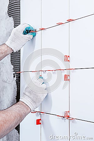 Ceramic tiles. The master lays ceramic tiles on the wall with the help of special devices. Stock Photo