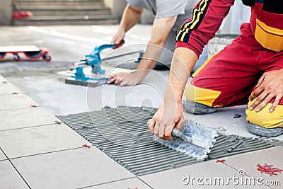 Ceramic Tiles. Tiler placing ceramic wall tile in position over Stock Photo