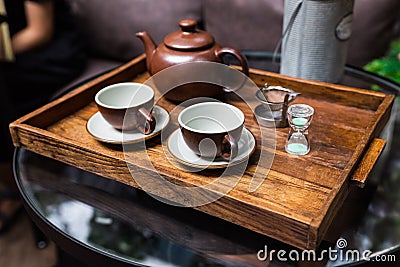 Ceramic vintage cups, mug and small sand clock, equipment for making dry flower with tea stainless steel tea strainer infuser. Stock Photo