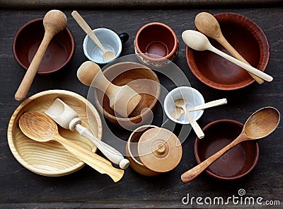 Ceramic, wooden, clay empty handmade bowl, cup and spoon on dark background. Pottery earthenware utensil, kitchenware. Stock Photo