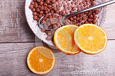 Cereal chocolate balls in bowl with milk. Sliced citrus on a table Stock Photo