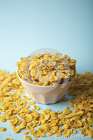 Cereal cornflakes for breakfast in a pink bowl on a blue background. Minamal art creative food concept Stock Photo