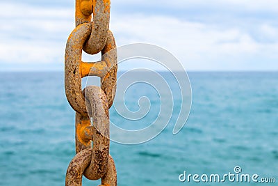 Chain and blue sea. Yellow mooring chain of cargo ship. Commercial shipment by sea. Stock Photo