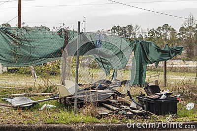 Chain link fence green tarp cover overgrown grunge dirty junk pile Stock Photo