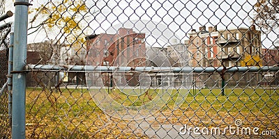 Chain-linked fence encircling a neglected, crumbling urban playground, symbolizing the decline in public spaces, concept Stock Photo