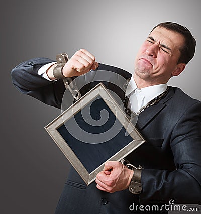 Chained businessman with a board Stock Photo