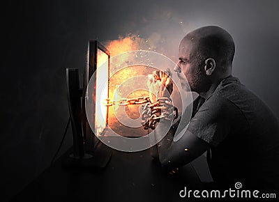 Chained to flaming computer Stock Photo