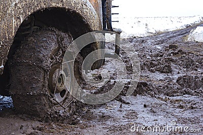 Chained up tire on a very muddy road. Stock Photo