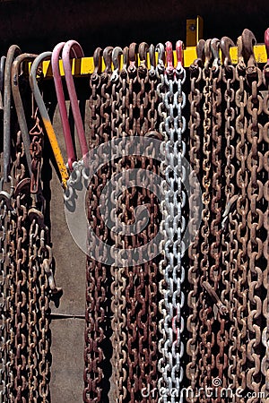 Chains hanging straight in a row with various hooks Stock Photo