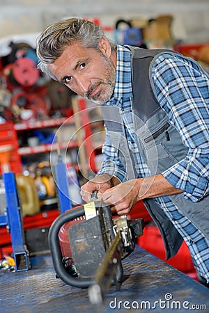 Chainsaw technician fixing electric saw Stock Photo