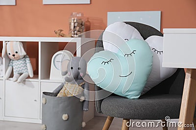 Chair with cute cushions in playroom, space for text. Interior design Stock Photo