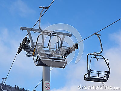 Chairlift ski lift in winter. Close up of an empty chair in a ski lift. The chairlift is out of order. Closed ski resort Editorial Stock Photo