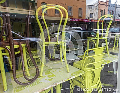 Chairs stacked up in a restaurant window Editorial Stock Photo