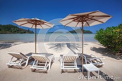 Chairs And Umbrella In tropical sandy beach Stock Photo