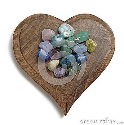 Chakra Crystal tumbled stones on wooden heart plaque Stock Photo