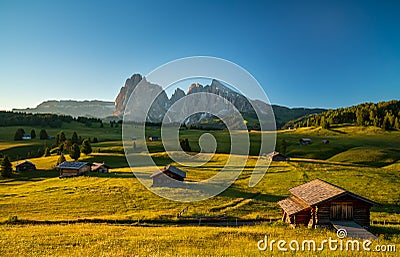 Chalets at Seiser Alm with Langkofel mountain in background at sunrise, Dolomites, South Tyrol, Italy Stock Photo