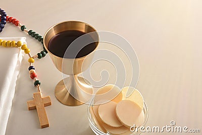 Chalice and consecrated host on table with cross elevated view Stock Photo