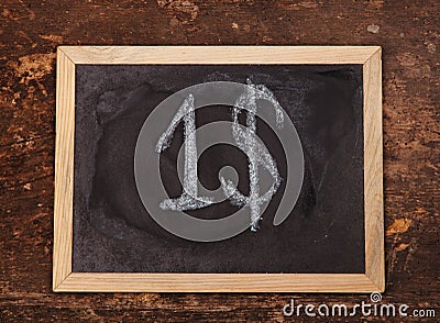 Chalk handwritten dollar sign on blackboard on wooden background Stock Photo