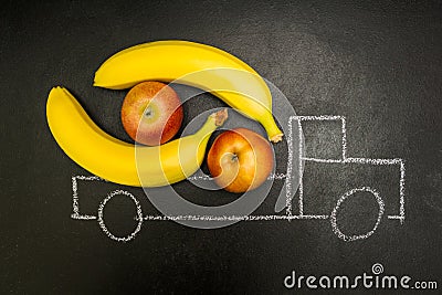 Chalk painted truck loaded with bananas and apples on a black background Stock Photo