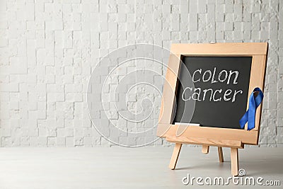 Chalkboard with blue ribbon and text Colon cancer awareness Stock Photo