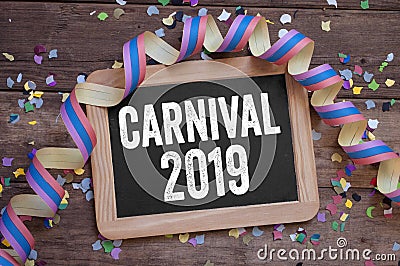 Chalkboard with streamers, confetti on wooden background with carnival 2019 Stock Photo