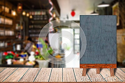 Chalkboard wood frame blackboard sign menu on wooden table, Blurred image background. Stock Photo