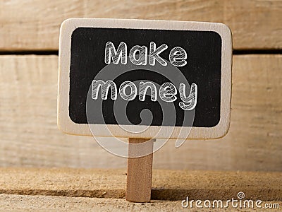 Chalkboard with word Make money on wood background Stock Photo