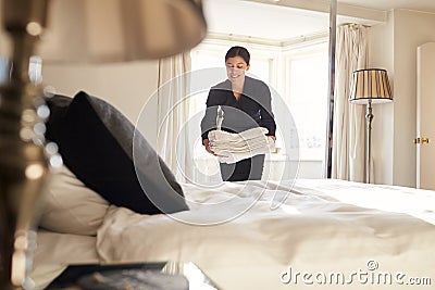 Chambermaid placing linen on hotel room bed, low angle view Stock Photo