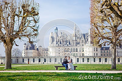 Chambord Castle, France. pair of lovers, couple sitting on bench on alley Stock Photo