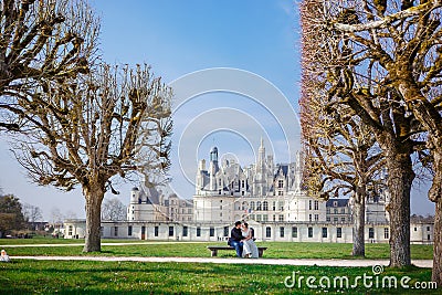 Chambord Castle, France. pair of lovers, couple sitting on bench on alley Stock Photo