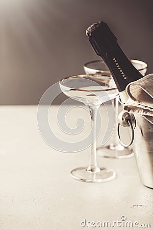 Champagne bottle in bucket and glasses on concrete background Editorial Stock Photo