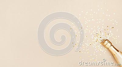 Champagne bottle with confetti stars on golden festive background. Christmas, birthday or wedding concept. Flat lay Stock Photo