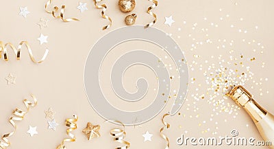 Champagne bottle with confetti stars, holiday decoration and party streamers on gold festive background. Christmas flat lay Stock Photo