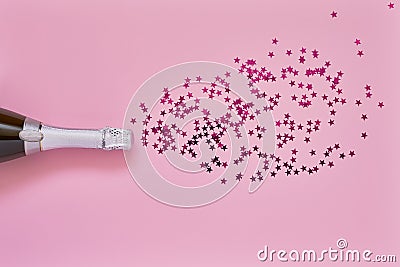 Champagne bottle with pink confetti stars on light pink background. Flat lay of christmas, anniversary, bachelorette, new year Stock Photo