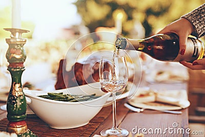 Champagne, dinner and hands with a woman pouring a drinking during a Christmas party outdoor. Tradition, celebration and Stock Photo