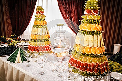 Champagne fountain and decorations from fruit on table setting a Stock Photo