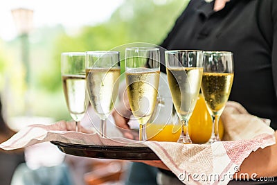 Champagne or sparkling wine in glasses in restaurant served by servant Stock Photo