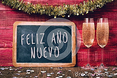 Champagne and text feliz ano nuevo, happy new year in spanish Stock Photo