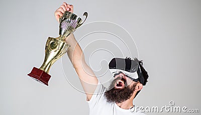 Championship online. Man bearded hipster vr headset holds golden goblet. Man winner virtual competition. Feel victory in Stock Photo