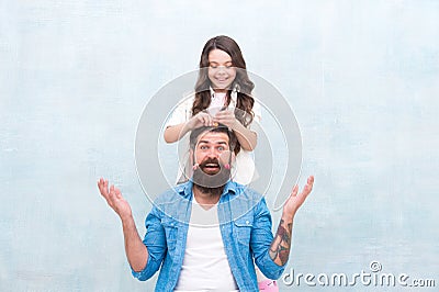 Change hairstyle. With healthy dose of openness any dad can excel at raising girl. Create funny hairstyle. Child making Stock Photo