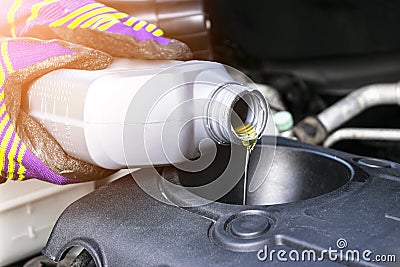 Change the Oil. Hand mechanic in repairing car. Close up oil for car engine. Motor oil pouring to car engine. Refuelling and pouri Stock Photo