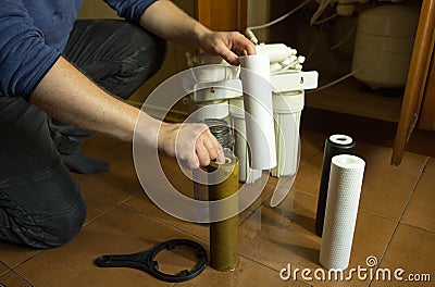 Changing filters in your home water purification system. The master prepared to replace the first filter 5 microns Stock Photo