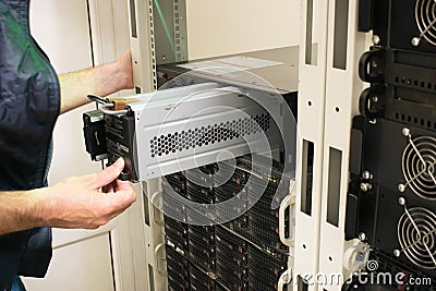 Changing the power module in the server room close-up. Working with equipment in the datacenter rack. Replacing the battery in an Stock Photo