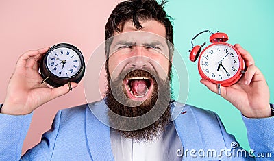 Changing time zones affect health. Does changing clock mess with your health. Man bearded hipster hold two different Stock Photo