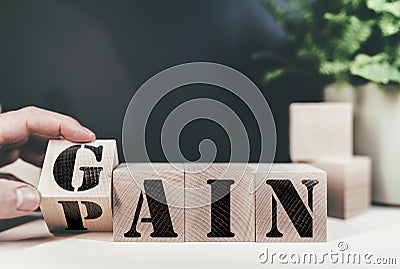 Changing word PAIN to GAIN on wooden blocks Stock Photo