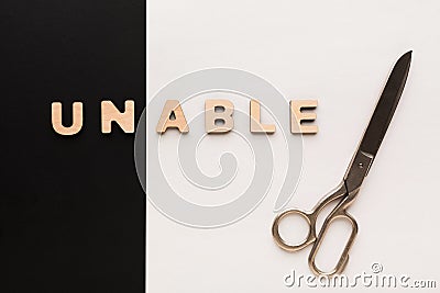 Changing word unable into able with scissors Stock Photo