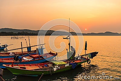 Chanthaburi, Thailand - February, 02, 2020 :Beautiful sunrise over sea with Silhouette of fishermen with yellow and orange sun in Stock Photo